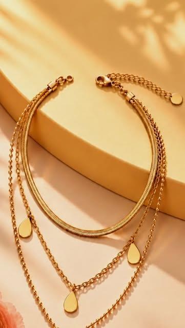 Goldenes Armband und Ketten mit tropfenförmigen Anhängern